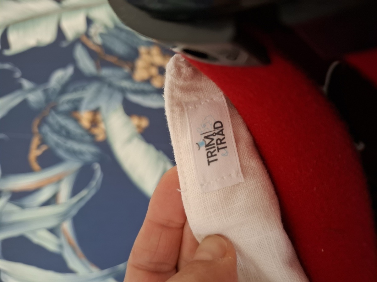 Närbild på Trim och Tråd-etiketten sydd i en dyna