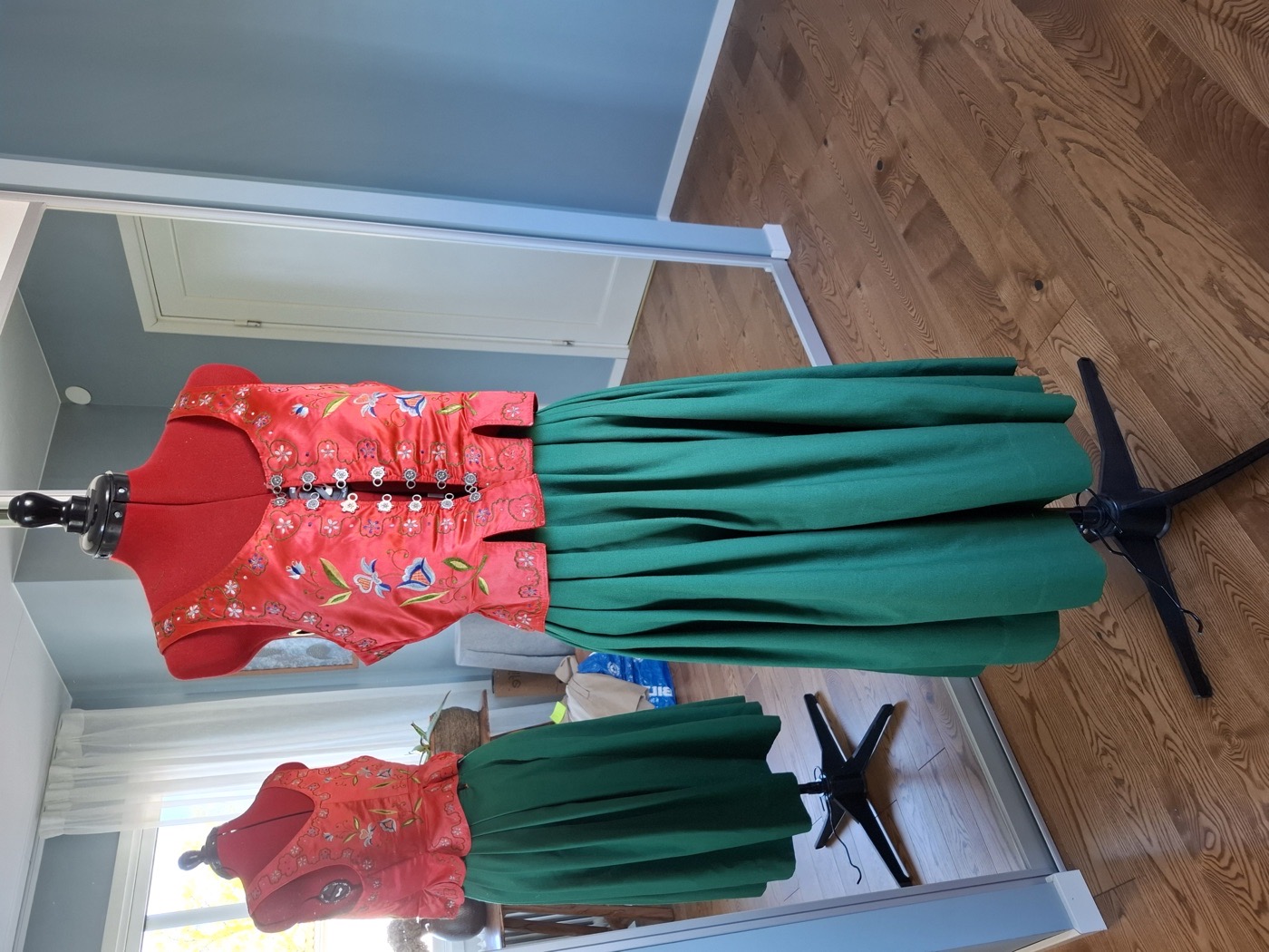 Färdigsydd folkdräkt med broderat rött liv och grön kjol